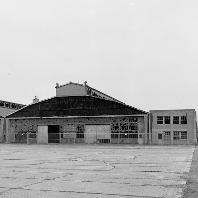 Black and white photograph of seaplane hangar and tarmac