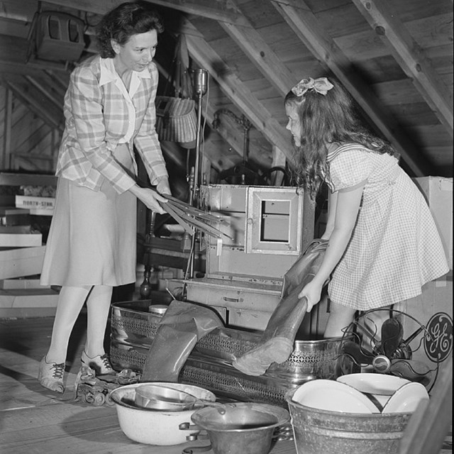 A woman and girl sort materials in an attic space