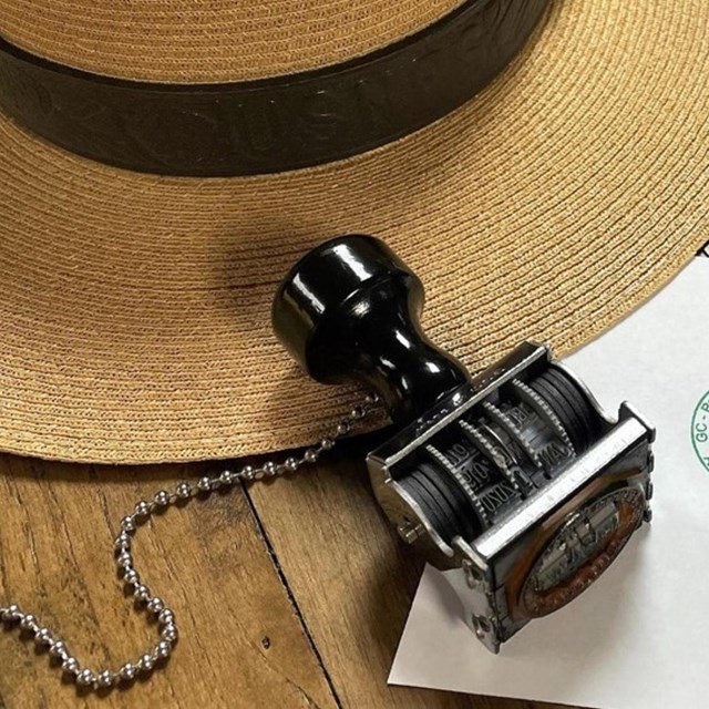 A date stamp, lying on its side on a piece of paper.