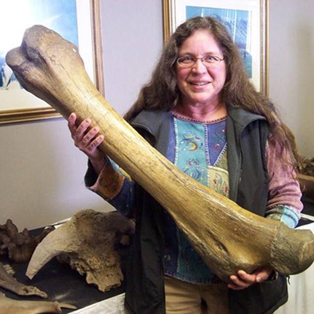 Margaret holding a mammoth leg bone