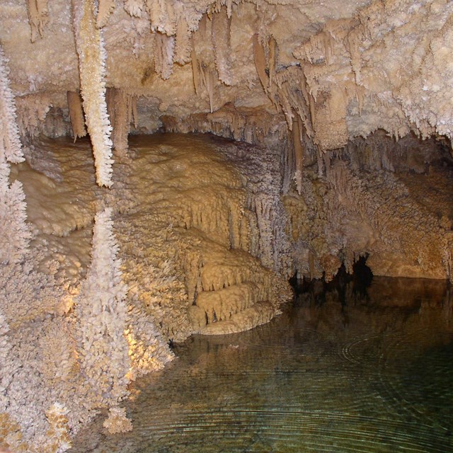 an underground pool and sparkly cave formations in a cave