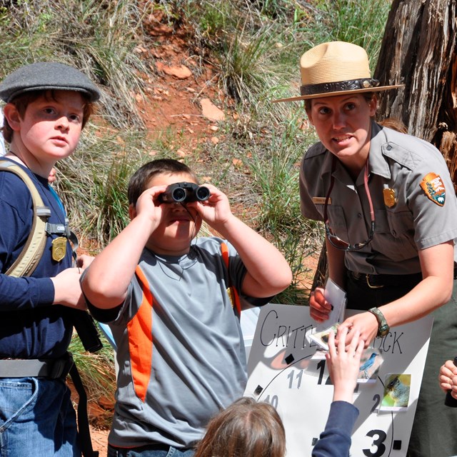 Ranger with kids looking for wildlife