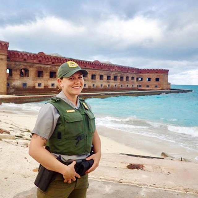 Erin stands in uniform on the beach at Dry Tortugas