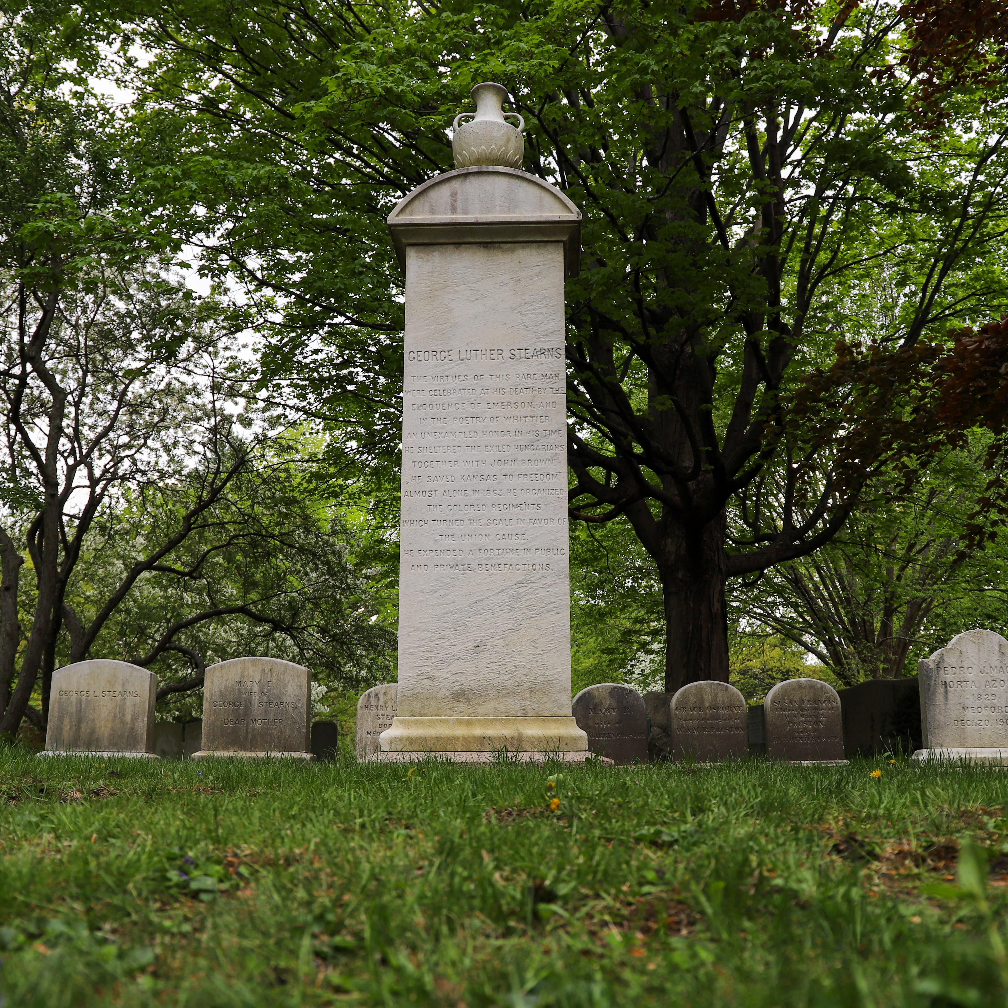 Cemetery with large stone monument centered in photo