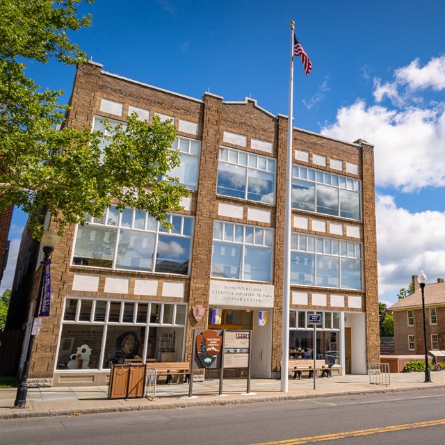 A three-story brick building with large windows along the front.