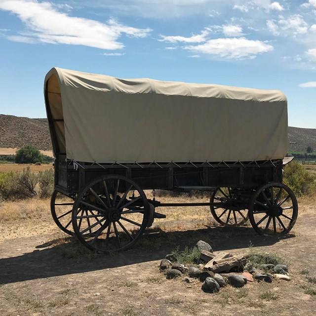 A covered wagon in a desert setting.