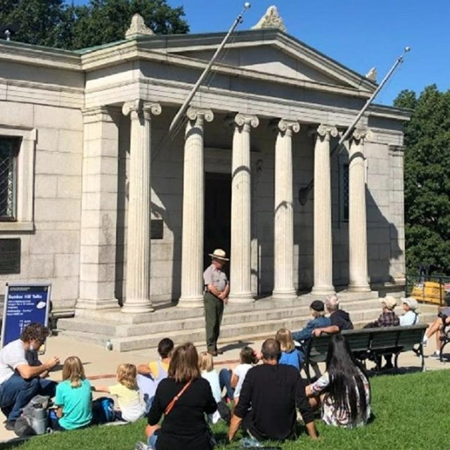 Ranger speaking to a crowd in front of the Bunker Hill lodge