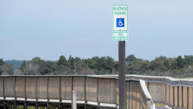 photo of handicapped access parking sign in front of wheelchair accessible boardwalk
