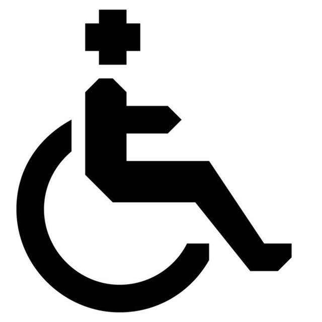 A black and white image of a figure in a wheelchair.