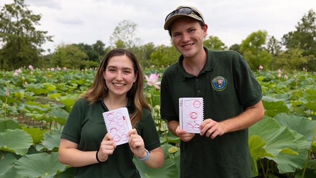 Two National Park Service interns show their passport stamp collection at Kenilworth Aquatic Gardens