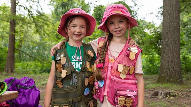 Two Junior Rangers display their Junior Ranger badge collections at Kenilworth Aquatic Gardens