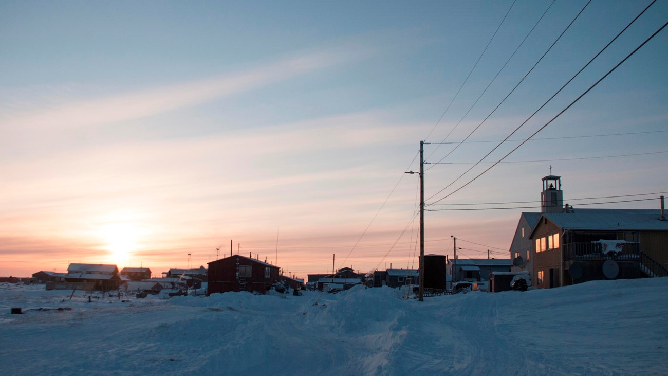 Snow covered village during the setting sun. 