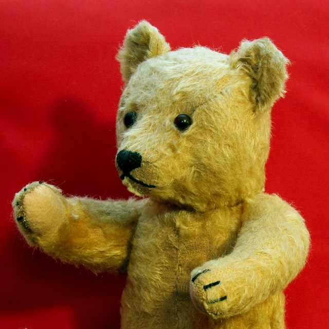 A toy bear with a red background. 
