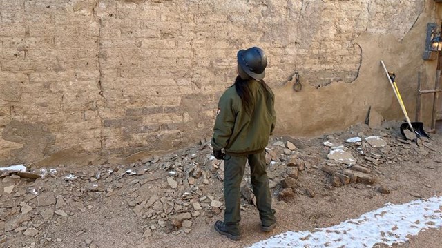 Park Ranger looks up at a failing wall