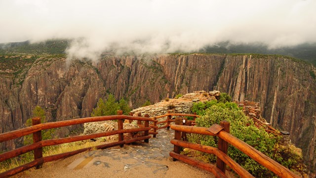 An overlook with wooden fencing along a canyon rim