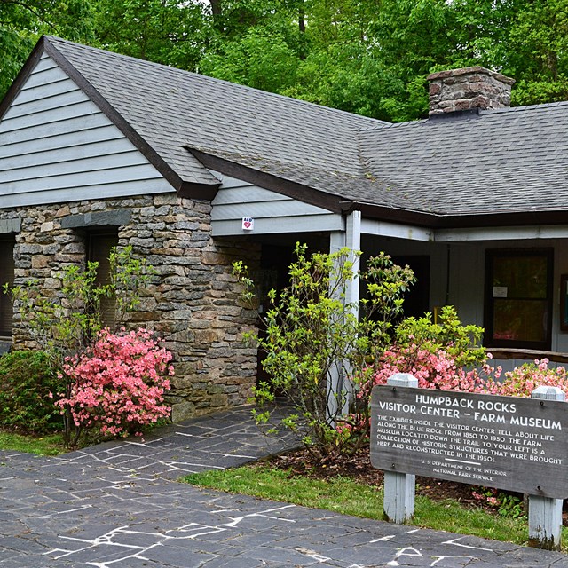 Humpback Rocks Visitor Center, a small, classic national park style building, with azaleas blooming.