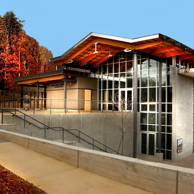 The main parkway visitor center in Asheville, with walls of windows overlooking fall color.