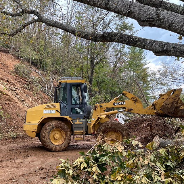 Tractor removing muddy debris