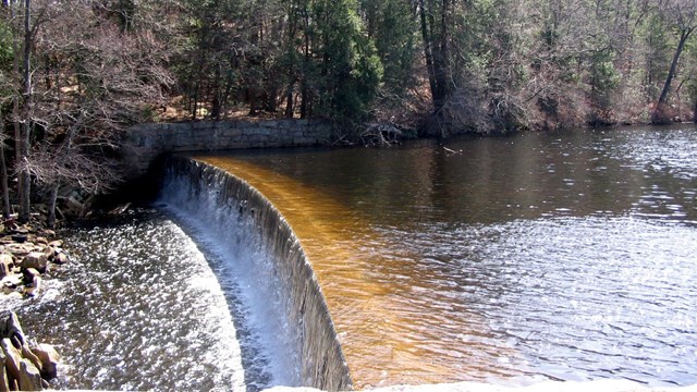 Dam at Slatersville with water flowing over it