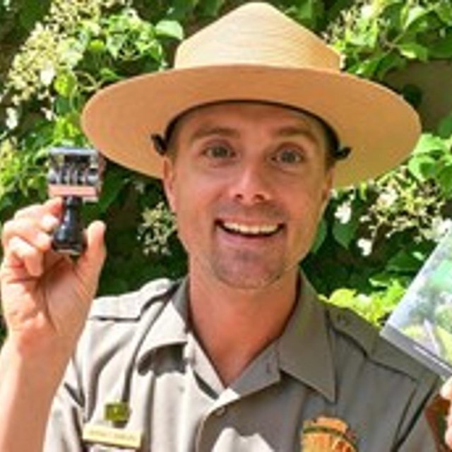 Ranger Andy holding the new Passport Book and Stamp