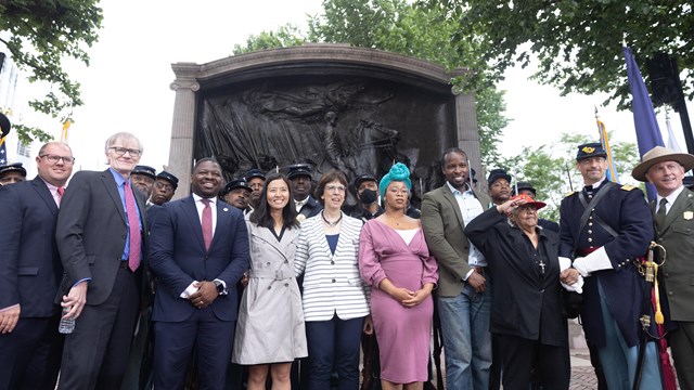 group of people standing in front of the Shaw 54th MA Memorial
