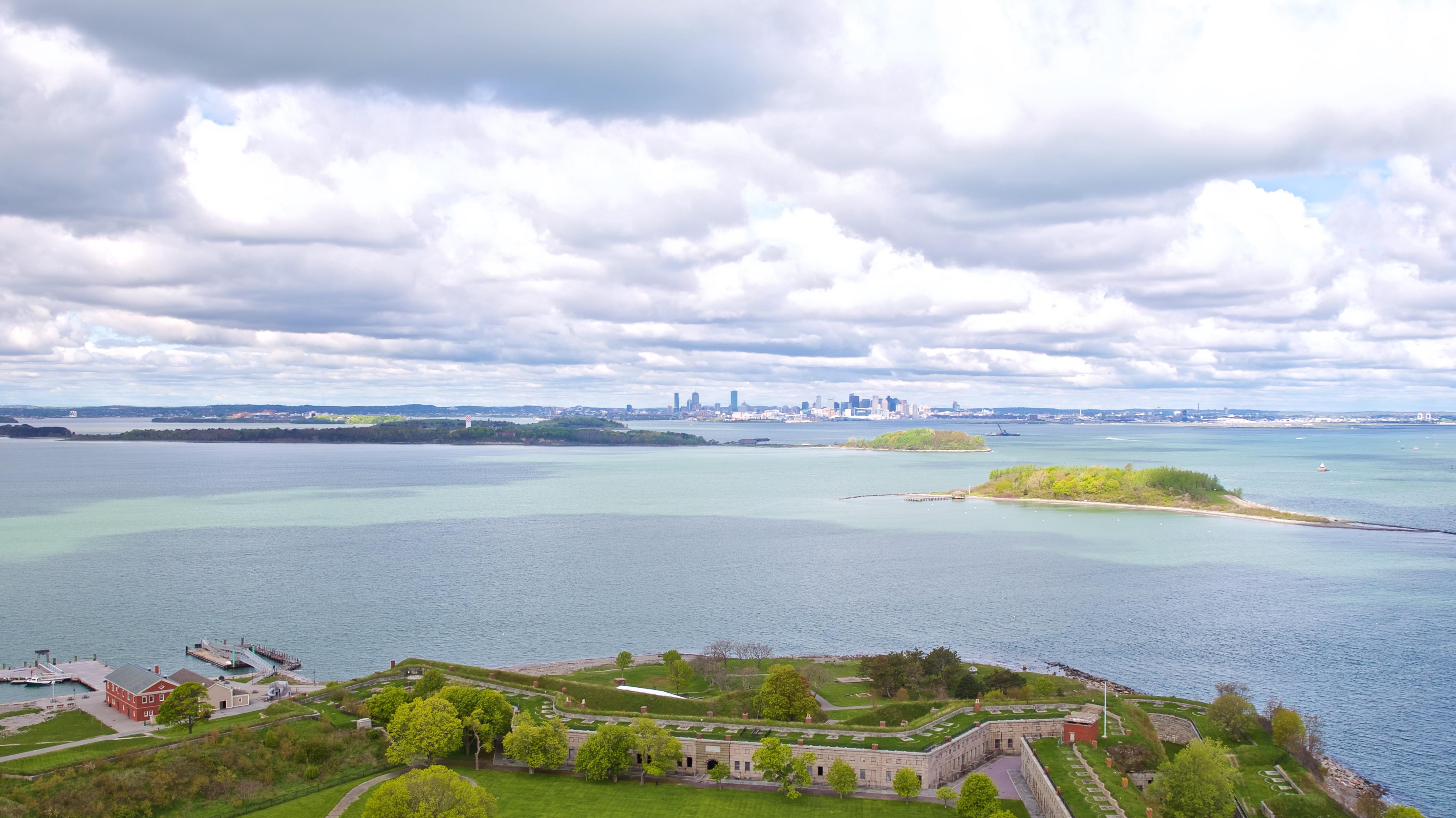 Aerial overlooking the fort on Georges Island with islands in the midground, skyline in background.
