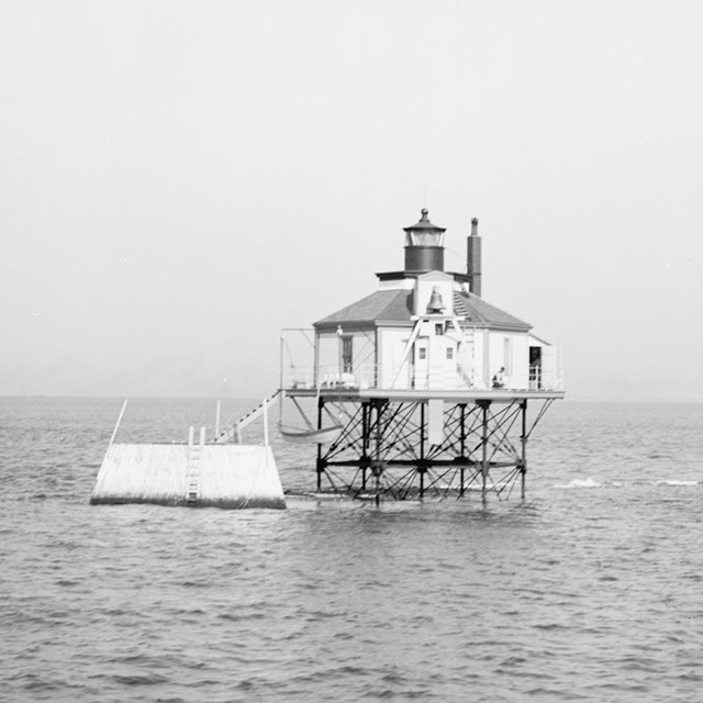 A lighthouse on posts above the water, making it look like a bug