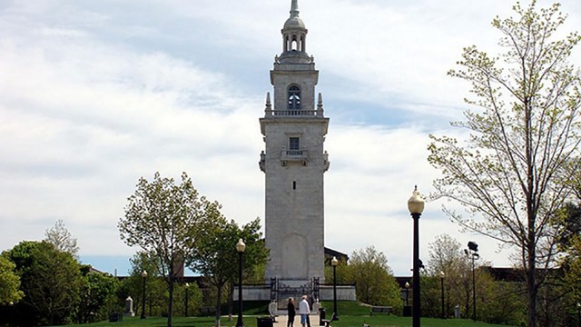 Dorchester Heights Monument with sidewalk leading up to it and grass on either side.