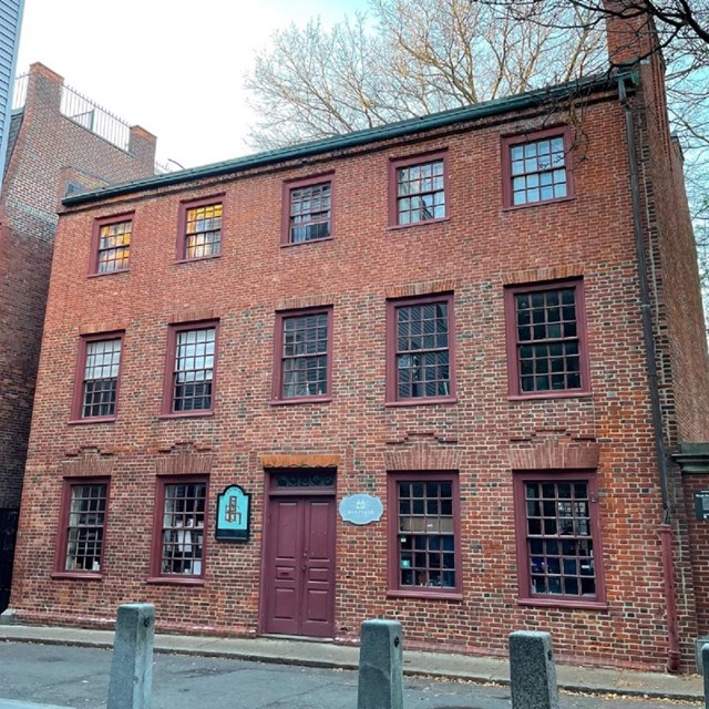 a three-story brick building with paned glass windows