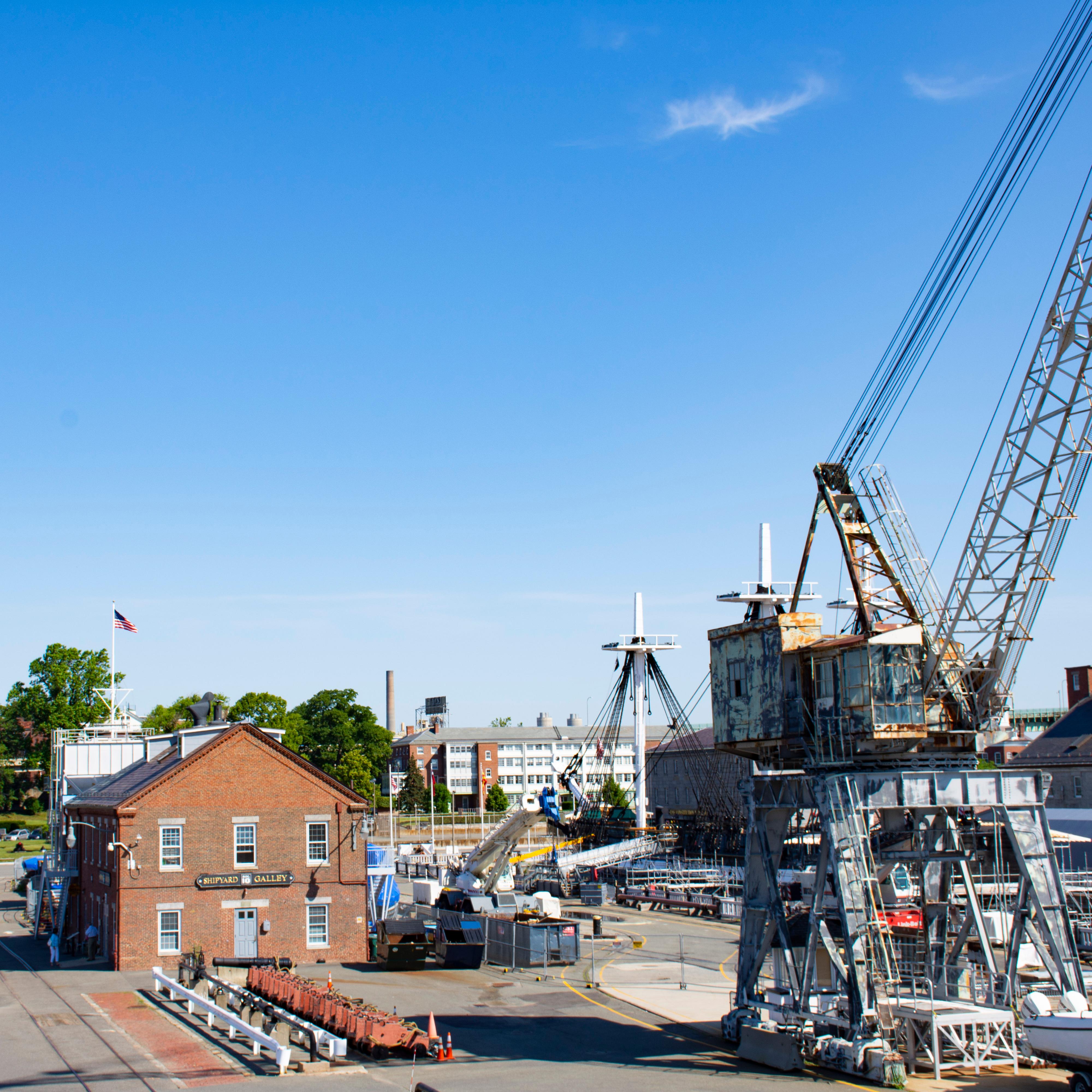 A crane and buildings at a navy yard. 