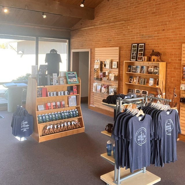 A photograph of a bookstore featuring books, tee-shirts and other merchandise.