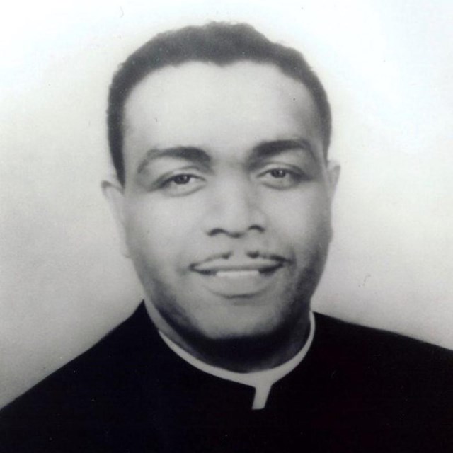 Oliver Brown smiles in his priest vestmants