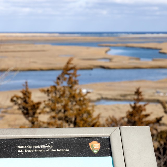 A photo of a vista with a national park sign in the bottom left.