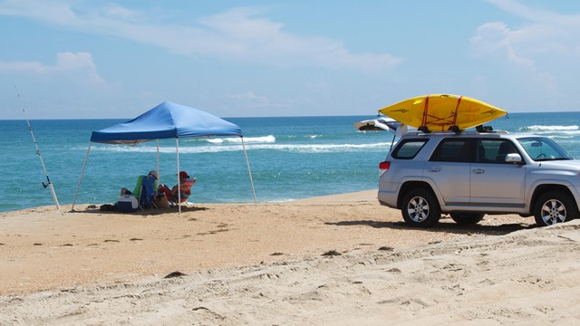 Visitors enjoying the beach after using their vehicle to get out onto the beach.