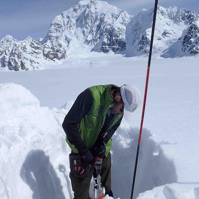 A researcher measuring snow depth.