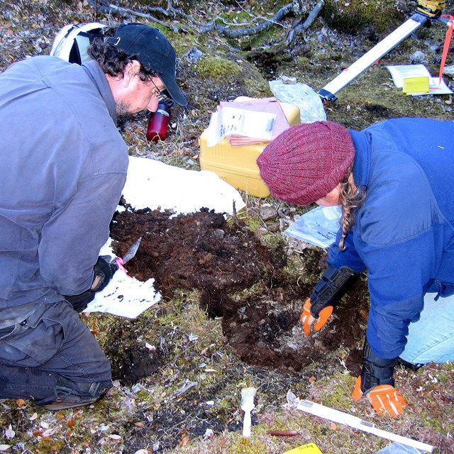 Male and female archaeologist dig a test hole at a potential archaeological site