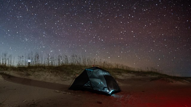 One tent on the beach at night. 
