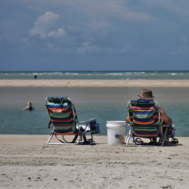 One person sitting in a chair next to a chair 