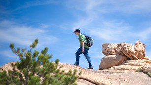 A man hikes on a rocky slope
