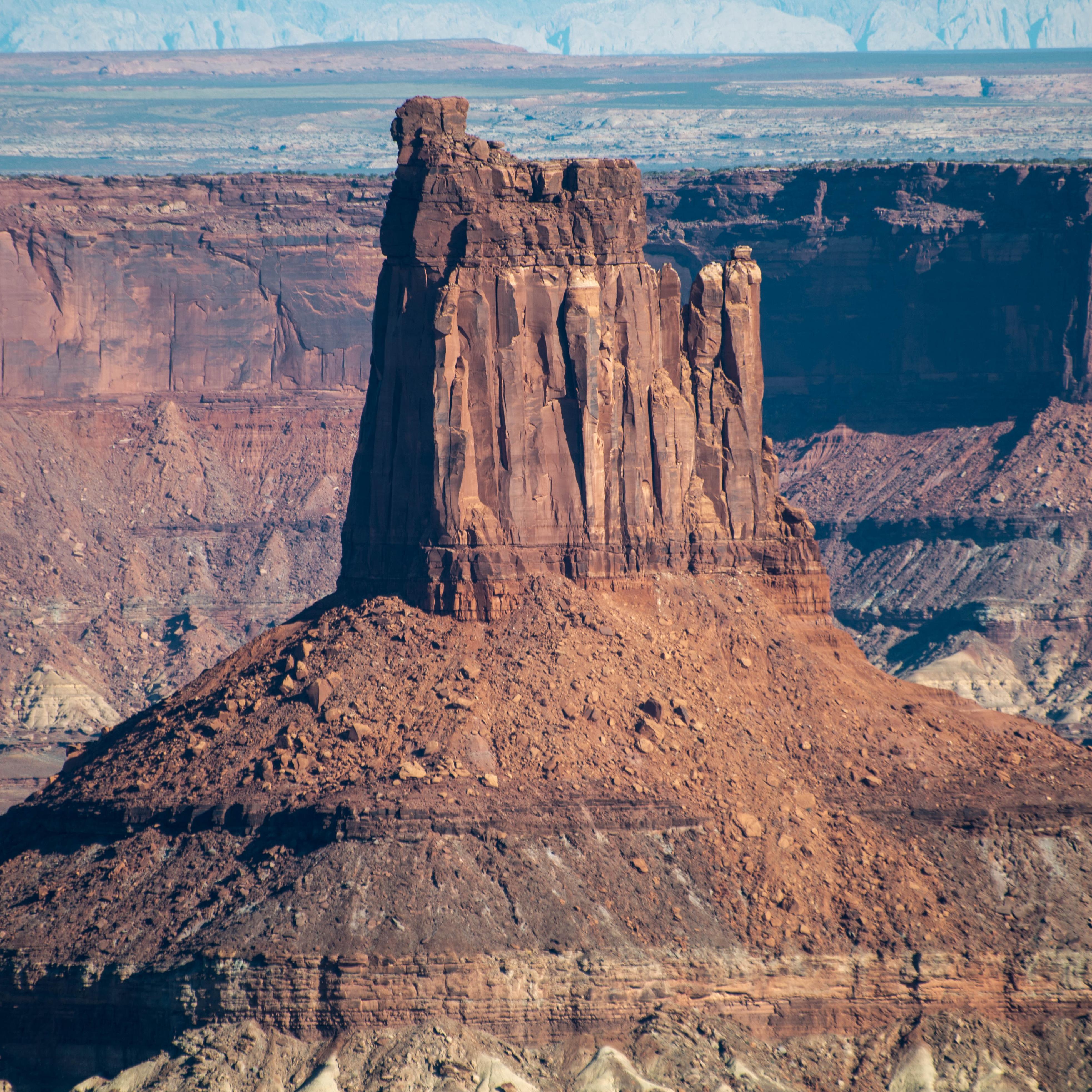 a tall sandstone tower with crumbled slopes beneath