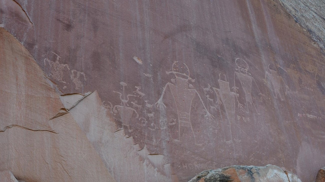 Petroglyphs of human-like figures in red sandstone.
