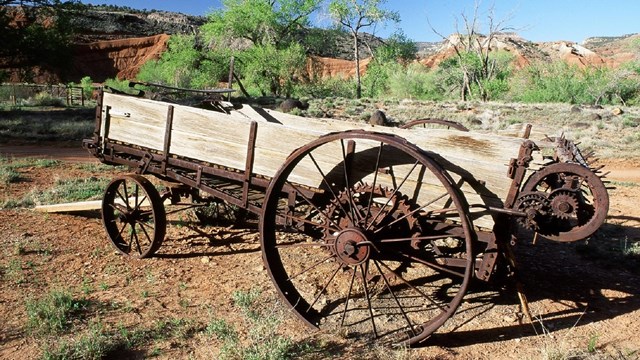 Photo of old, broken wagon in a field.