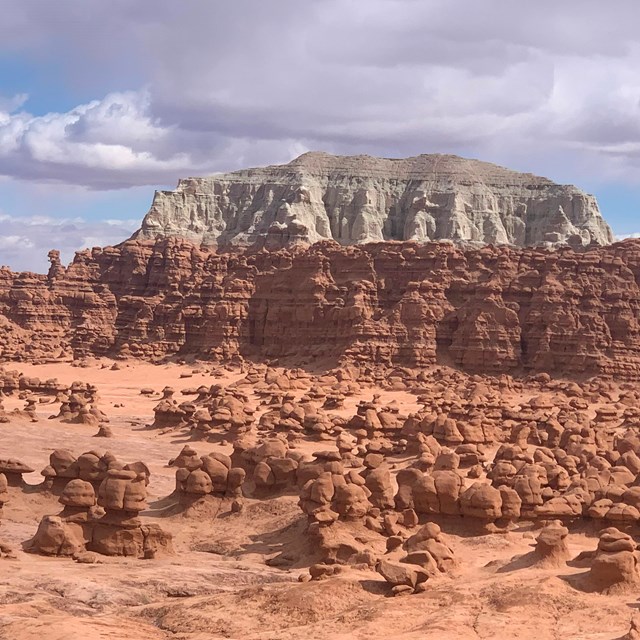 small hoodoos shaped like goblins in a red and gray landscape. 