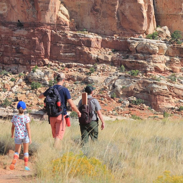 a man wearing a helmet bicycles on a path