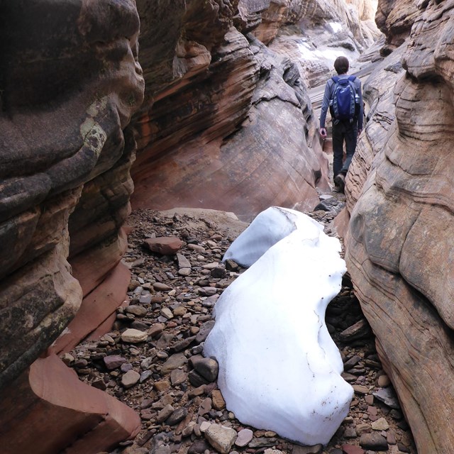 Narrow slot canyon with snow and hiker