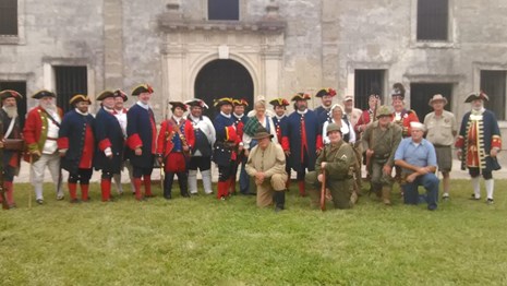a group photo of reenactors in uniforms from many different time period