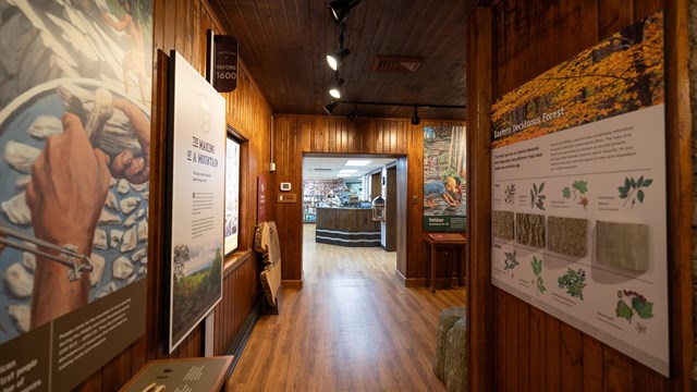 Exhibits in a visitor center with wood floors and panels on the walls.