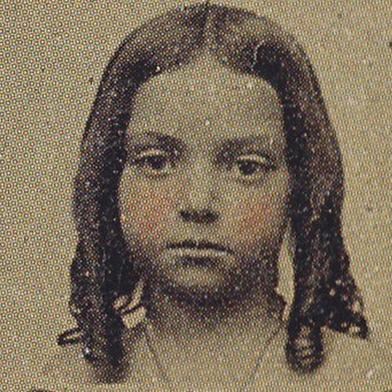 A framed 1800s photograph shows a little girl in a dress posing on a chair. 