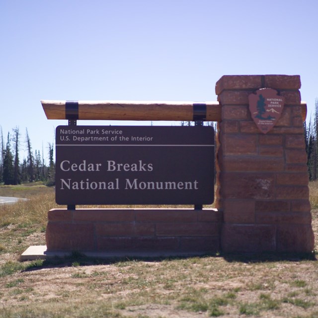 Stone and wood sign for Cedar Breaks National Monument. 