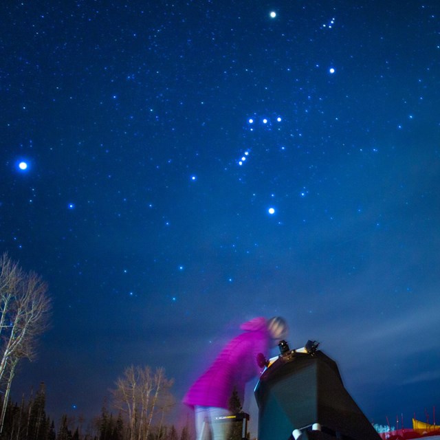 A park visitor peers into a telescope for a closer view of the stars during an astronomy program.